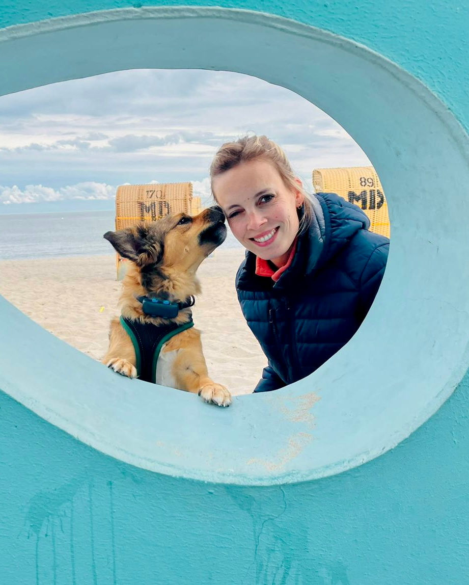 Junge Frau mit Mischlings Hund am Strand