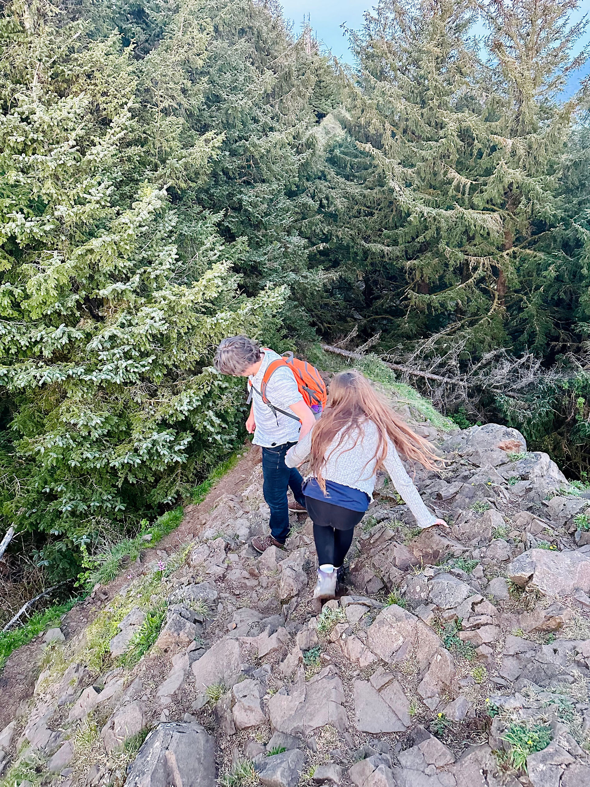 Girl and man hiking down mountain