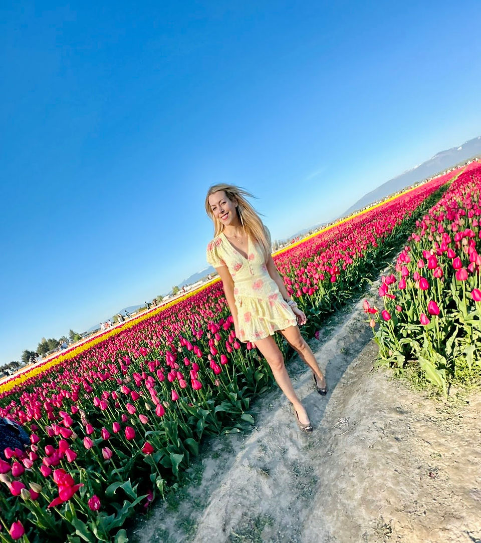 Woman walking through rows of tulips