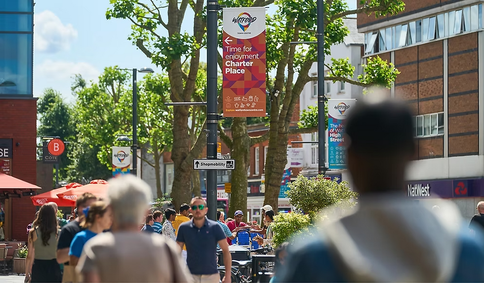 People walking on street below 'Charter Place Watford BID 2022' banner.