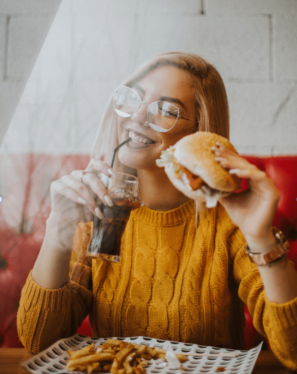 Girl eating a burger in a restaurant