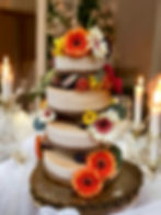 Tiered cheesecake event cake decorated with fresh flowers