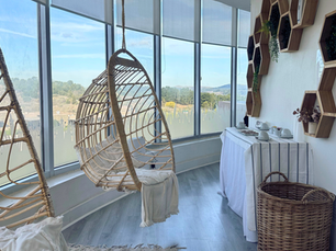 Sala de relax luminosa con sillones colgantes tipo huevo y vistas panorámicas a las sierras en Spa en Tandil.