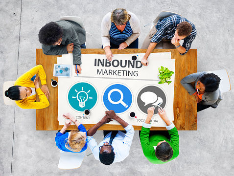 ista aérea de equipo diverso trabajando en mesa de madera con gráfico de Inbound Marketing Content Search Social Media.