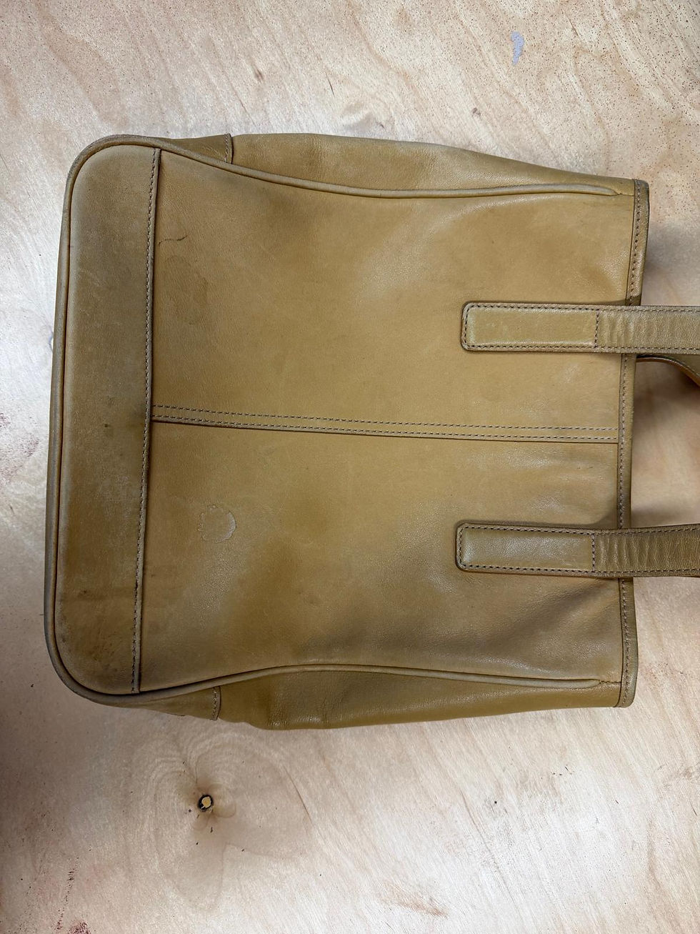Before leather purse restoration in San Leandro, CA showing a genuine leather handbag with scratches, stains, faded color, scuffs, and surface wear before professional leather cleaning, color restoration, repainting, and refinishing by All Leather Works LLC.