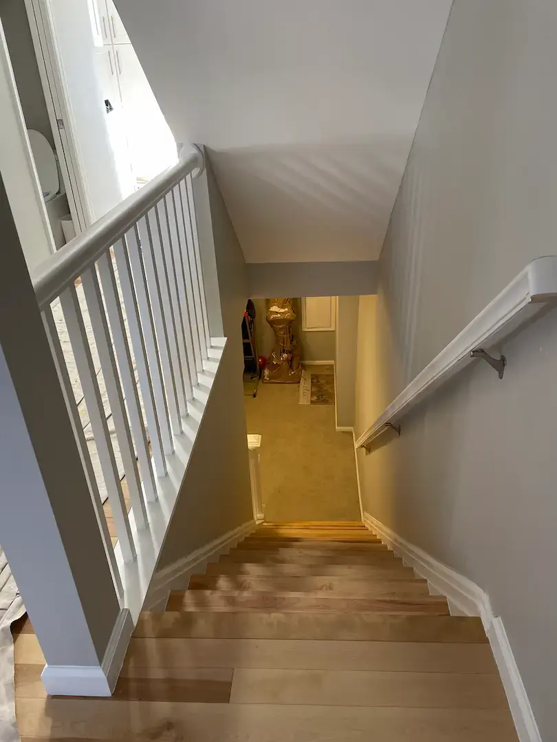 Interior staircase renovation with updated wood treads and white balusters in Burke VA home