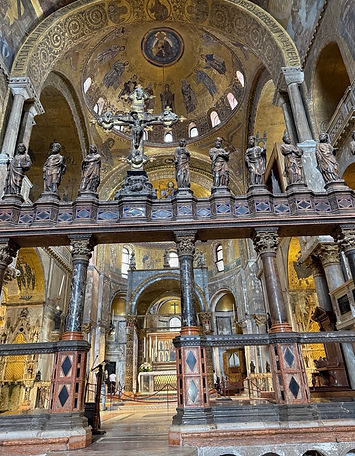 Statues and columns against a gold domed ceiling in St. Mark's Basilica in Venice, Italy