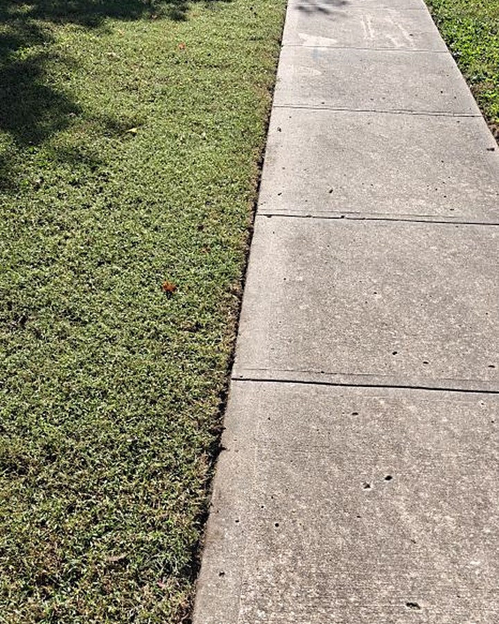 Crisp, freshly edged sidewalk beside a mowed front lawn