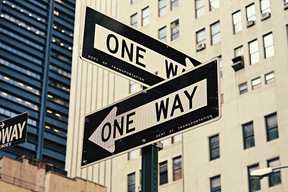 Two one way signs on a street symbolising the difference between emotional and rational Facebook app marketing strategies..