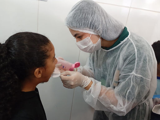 Profissional realiza aplicação de flúor em estudante durante oficina em Ceilândia