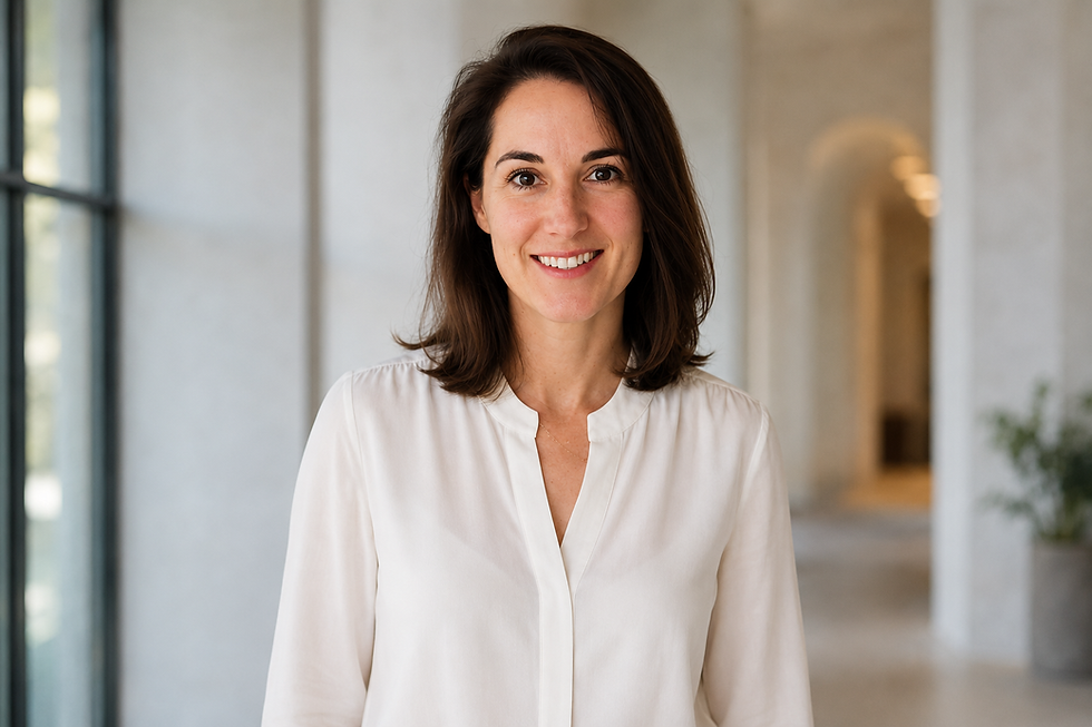 Woman in a white blouse standing in a bright, modern hallway