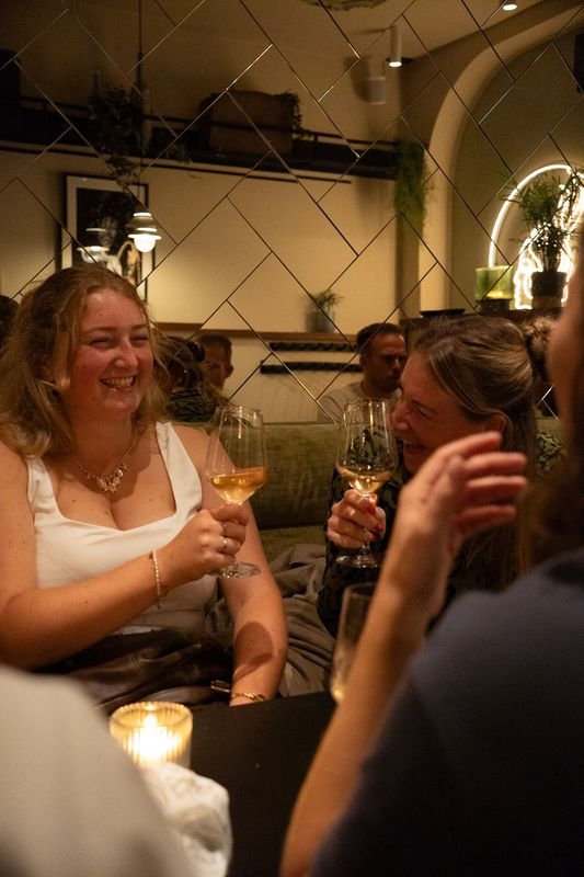 Twee jonge meiden proosten met wijn in een bar in Maastricht tijdens Grow on the go Mindful Sip & Step.