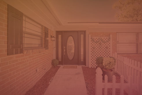 Residential home exterior with brick, door, walkway, and white picket fence Home