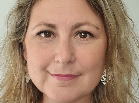 Photo of Di Thompson looking happy, but serious, professional, with shoulder length blonde-ish, light brown hair