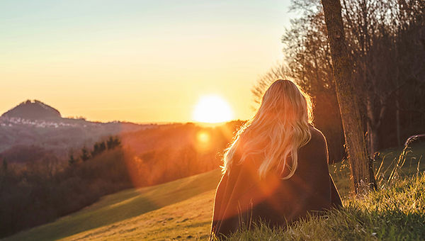 Woman sits on mountain, representing peace from therapy in Winter Park, Vail, Steamboat, Breckenridge, Telluride, Grand County, or Summit County.