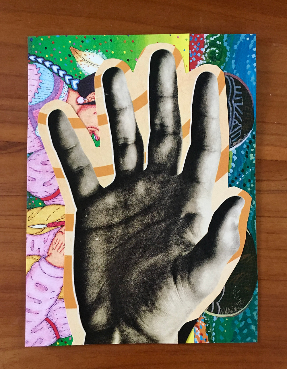 A picture of a hand over abstract designed backgrounds in a mixed media collage.