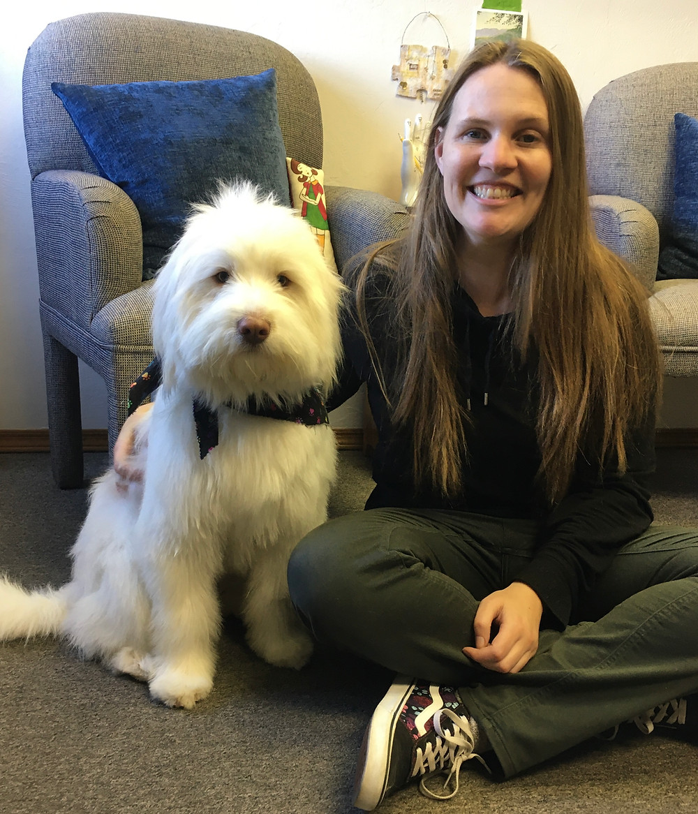 The author Jackie Schuld sits next to her dog, Egon