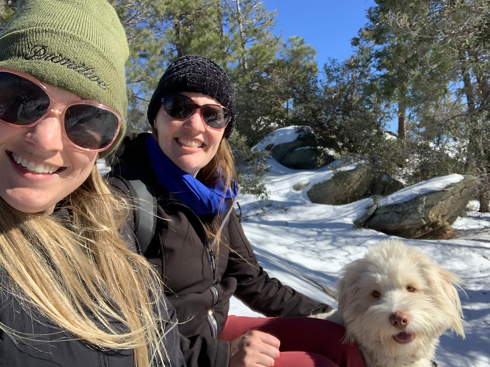 A photograph of Art Therapist Jackie Schuld, her sister, and her dog hiking on Mt. Lemmon in the snow.