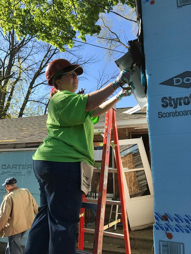 Jody Komyathy tearing siding down to help Habitat for Humanity 2017.