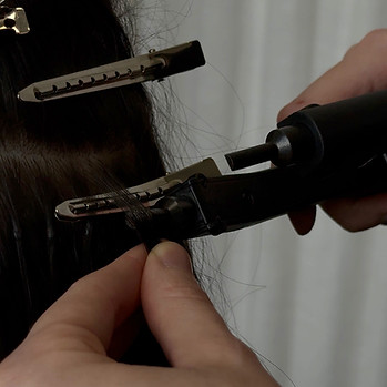 a keratin bond is being installed on a section of hair