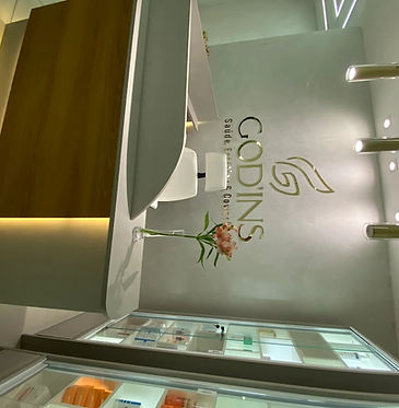 recepção sofisticada, premium e acolhedora da God'ins com o logotipo na parede emdourado.