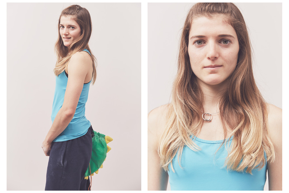 Portrait of a woman climber wearing a dinosaur chalk bag, taken at the Women's Climbing Symposium.