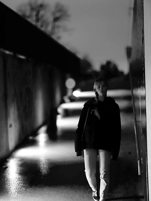 Frau läuft im Dunkeln in eine Unterführung