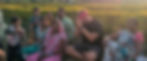 J Currie seated with locals in an Indian village hands in prayer pose