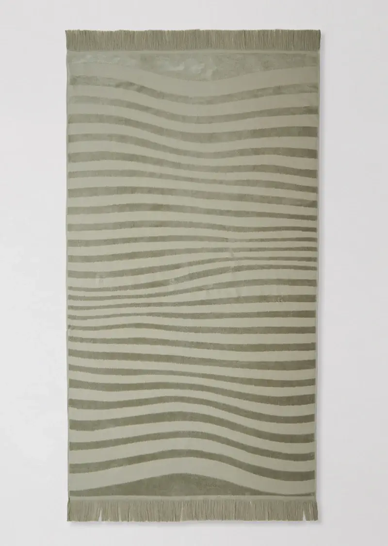 The Ripple Beach Towel was designed for fuss-free beach days and lazing by the pool.  Shown in sage.