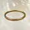 Thumbnail: This sleek and slim Paros Bangle is your style essential.  18K gold plated.