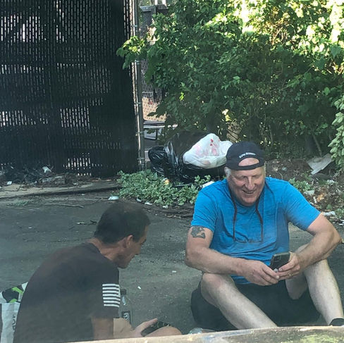 HLI sitting with homeless man