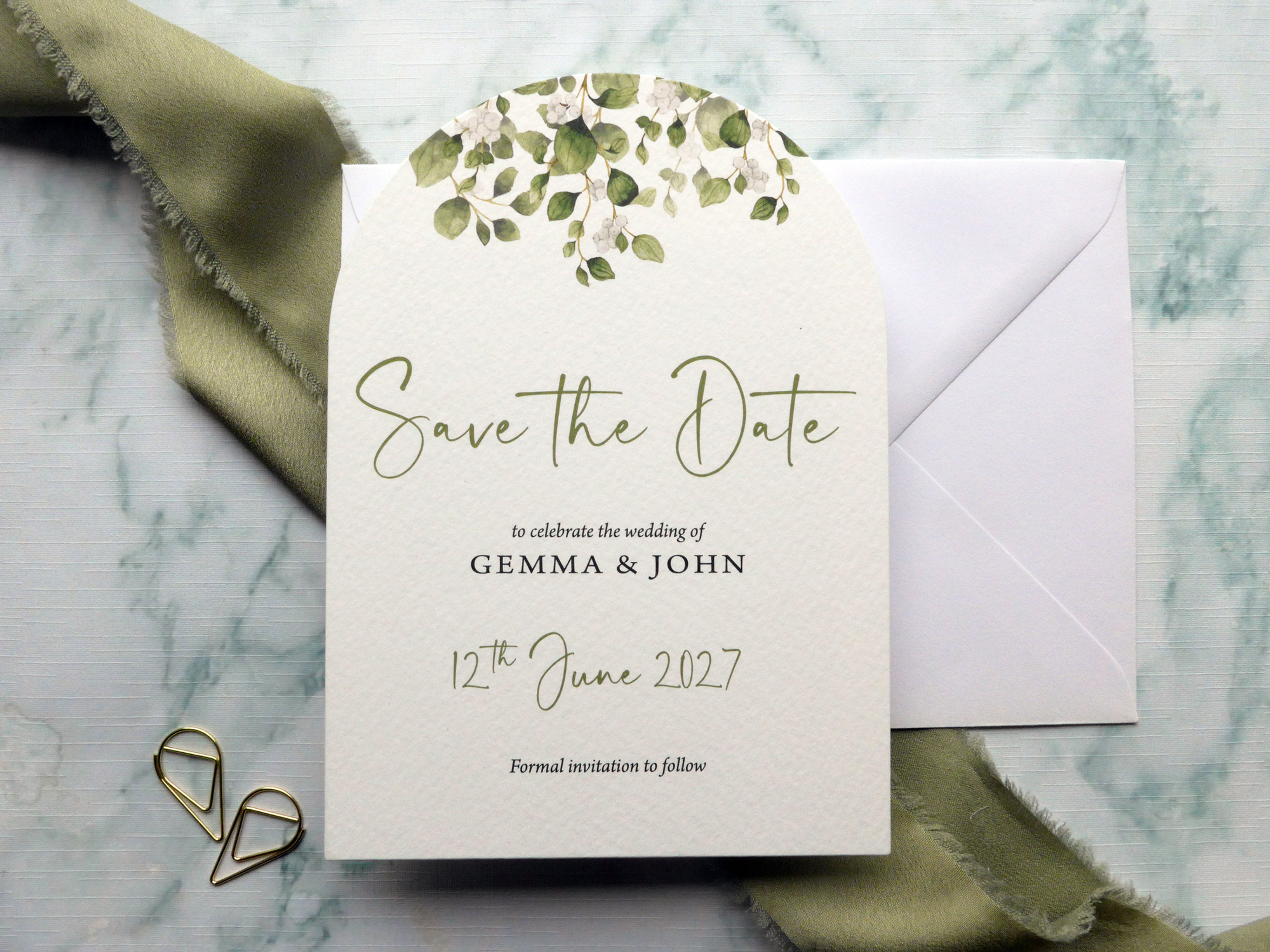 Arch-shaped luxury botanical wedding save the date card with sage green foliage and modern calligraphy