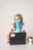 Queer, neurodivergent therapy website designer in Halifax sitting, drinking, looking left.