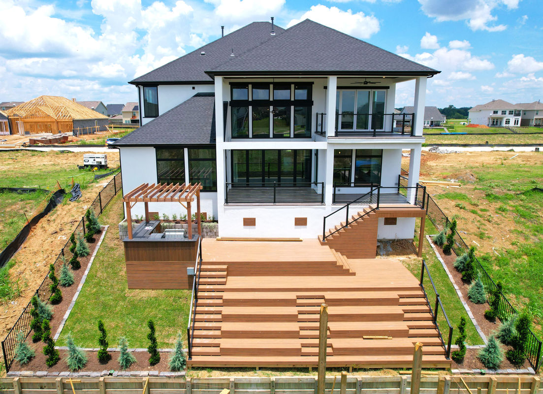 Drone aerial of modern Houston home showing outdoor deck and landscaping