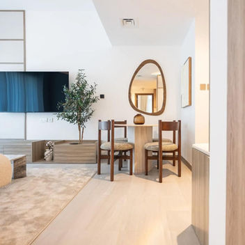 Modern living room with a TV, mirror, and small dining set