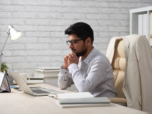 Startup founder reviewing digital marketing plans on a laptop at a desk.