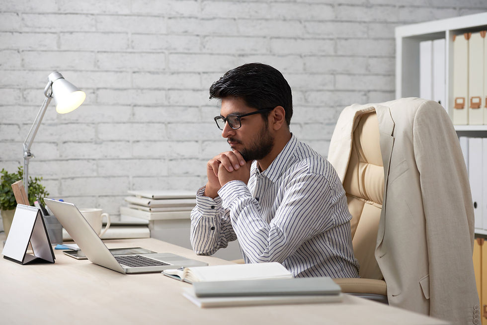Startup founder reviewing digital marketing plans on a laptop at a desk.