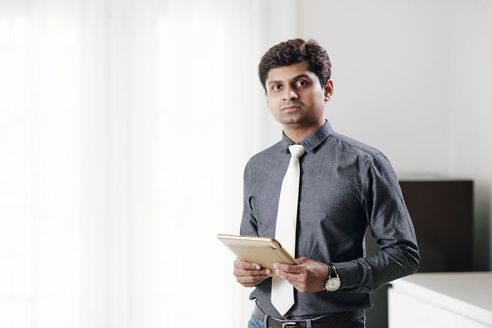 A professionally dressed man holding a tablet, representing mistakes new managers make, such as poor communication, lack of delegation, and ineffective leadership strategies.
