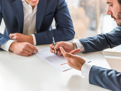 Two businessmen in suits reviewing a contract together, illustrating collaboration between Sales and Legal to speed up deal approvals.