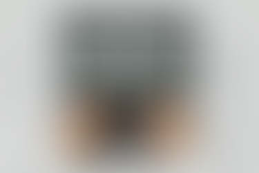 Hands typing on a laptop keyboard with a code editor open on the screen, showing lines of software code in a clean, minimal workspace.