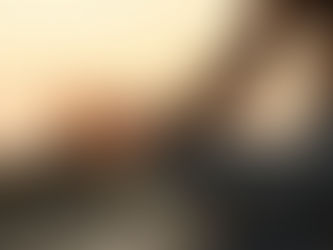 Close-up of a woman sitting in a lotus meditation pose at sunset, her hand resting on her knee in a relaxed mudra, with warm golden light and a softly blurred natural background creating a calm, mindful atmosphere.