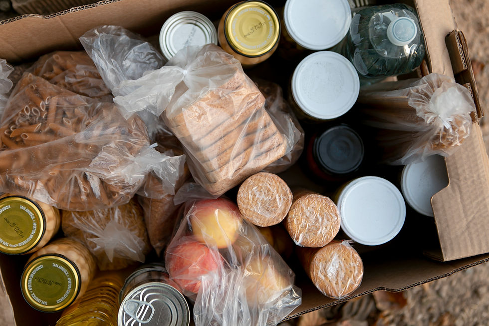Top view of a food donation box filled with various packaged goods, showcasing CPG product innovation in sustainable packaging and diverse food items.