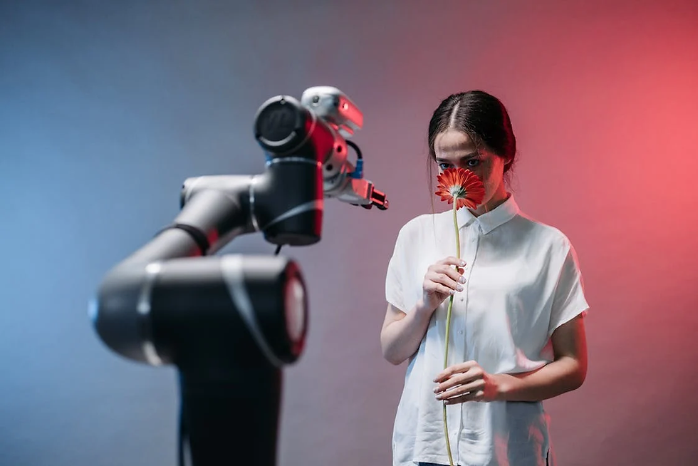 Woman smelling a red flower, with a robotic arm in the foreground.