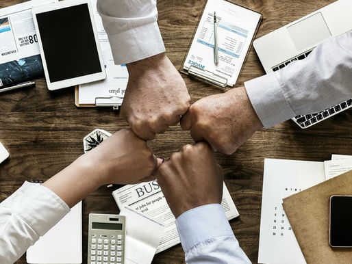 Business team demonstrating collaboration and unity during a planning session, illustrating how cross-functional alignment helps organizations break down silos and improve sales growth.