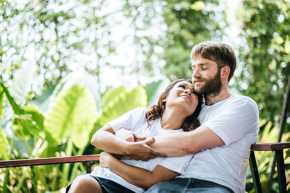 Happy couple relaxing together outdoors on a park bench
