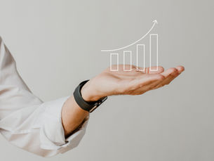 Businessman’s hand holding an upward-trending bar graph illustration—symbolizing a modern shift in sales leadership focus from purely hitting numbers to driving strategic, long-term growth in 2025.