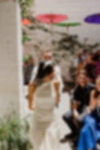 A couple walks through a crowd smiling with delight - the guests are all smiling too