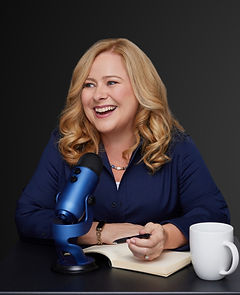 Lisa Wade, a professional woman with a pen, journal, coffee mug and leaning into a podcast microphone