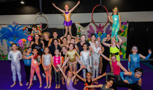 Group of young performers posing together with vibrant costumes for a photo
