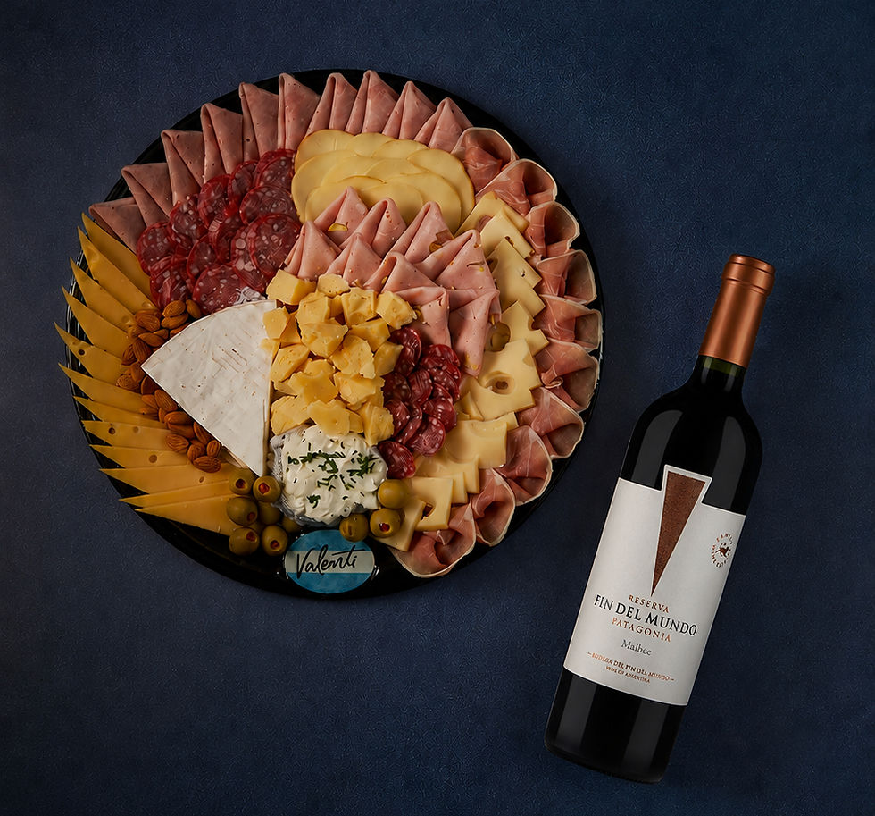 Jamón crudo tipo Parma estacionado, mortadela con pistachos, una selección de quesos y una botella de vino de Bodega Del Fin Del Mundo integran la propuesta especial de Valenti.